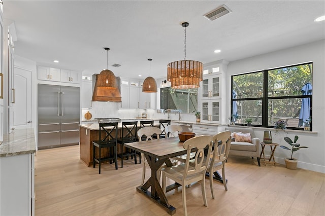 dining space with light wood-style flooring, recessed lighting, visible vents, and baseboards