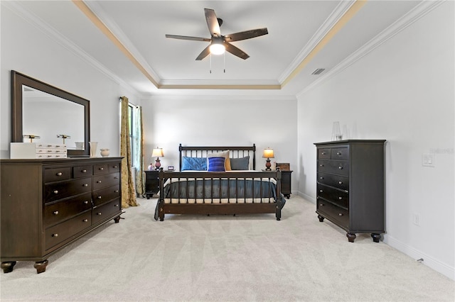 bedroom featuring baseboards, light carpet, a raised ceiling, and crown molding
