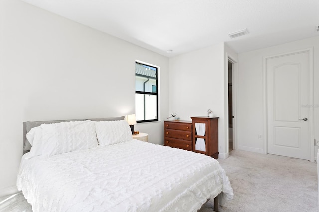 bedroom featuring light carpet, visible vents, and baseboards