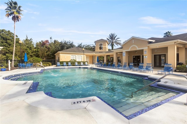 community pool with a patio and fence