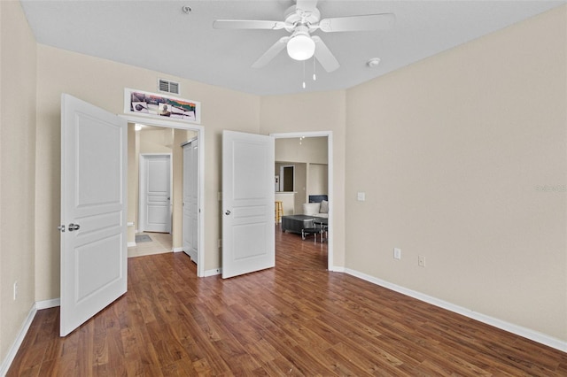 unfurnished bedroom with wood finished floors, visible vents, and baseboards