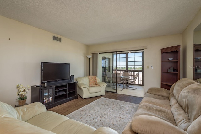 9860 62nd Ter N Unit 1051, Saint Petersburg, FL 33708 - living room with wood finished floors, a textured ceiling, and visible vents