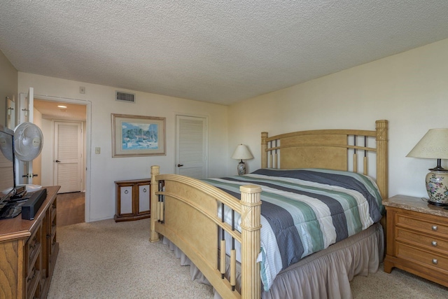 9860 62nd Ter N Unit 1051, Saint Petersburg, FL 33708 - bedroom featuring a closet, a textured ceiling, visible vents, and light colored carpet