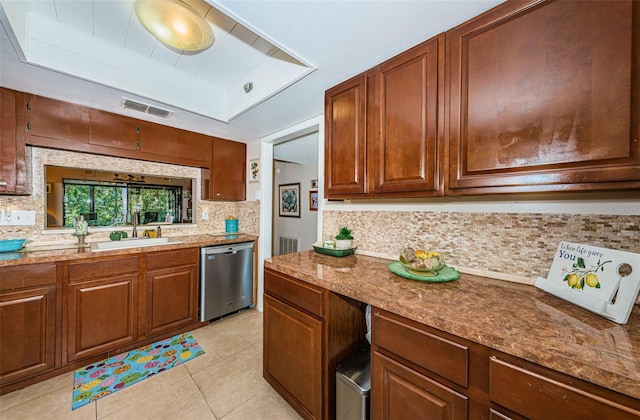 kitchen featuring stainless steel dishwasher, tasteful backsplash, a sink, light tile patterned floors, and visible vents