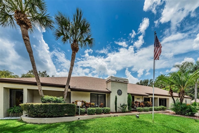 ranch-style house featuring a front yard and stucco siding