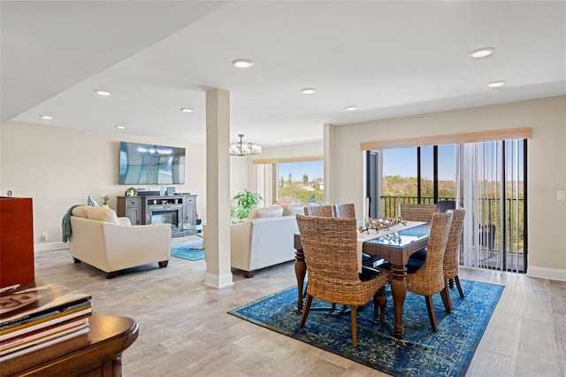dining space with baseboards, light wood-style floors, recessed lighting, and a chandelier