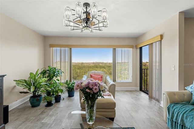 living room featuring baseboards, wood finished floors, and a notable chandelier
