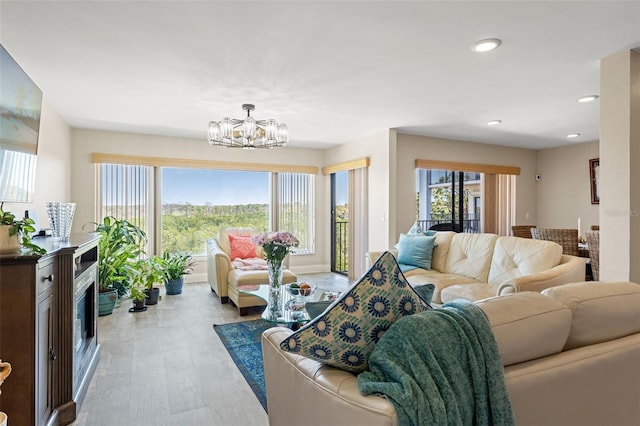 living room featuring a wealth of natural light, an inviting chandelier, recessed lighting, and light wood-type flooring