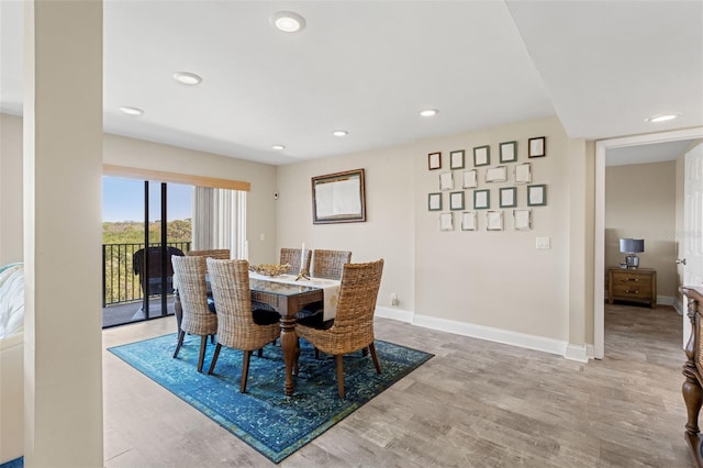 dining space featuring baseboards, wood finished floors, and recessed lighting