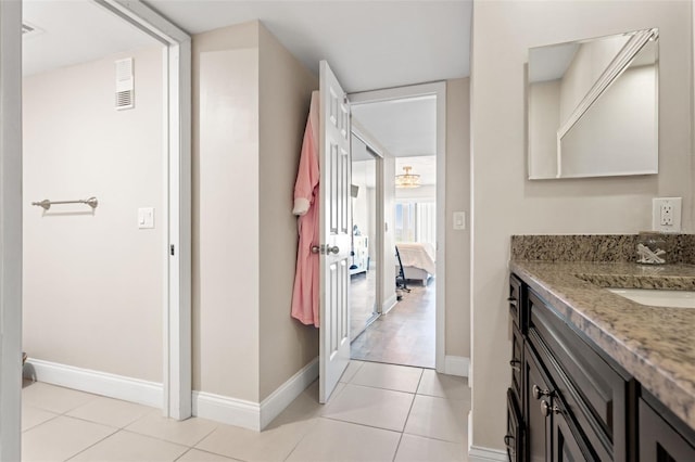 ensuite bathroom with tile patterned floors, vanity, ensuite bath, baseboards, and visible vents