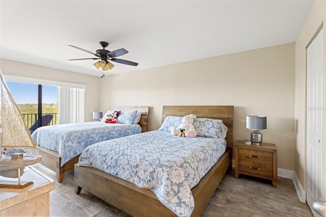bedroom featuring baseboards, access to exterior, wood finished floors, and a ceiling fan