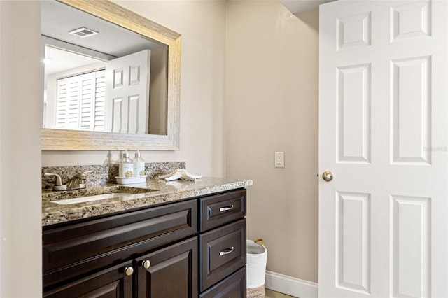 bathroom featuring baseboards, visible vents, and vanity