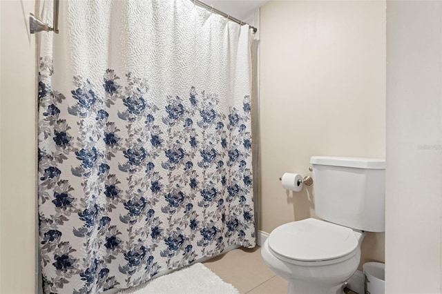 bathroom with tile patterned floors, a shower with shower curtain, toilet, and baseboards