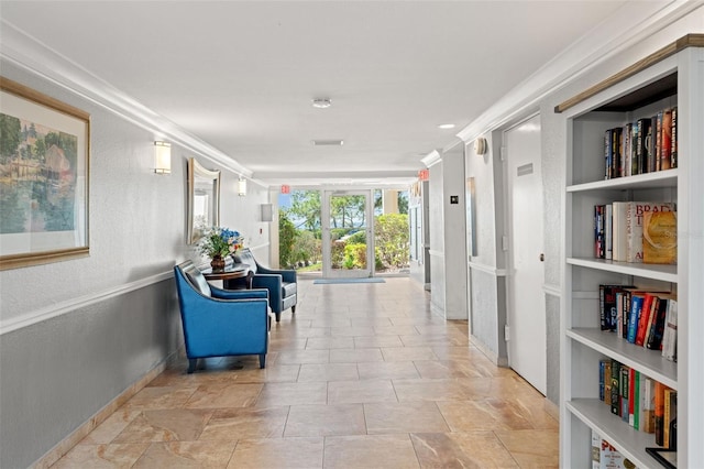 hallway featuring a textured wall, ornamental molding, and built in shelves