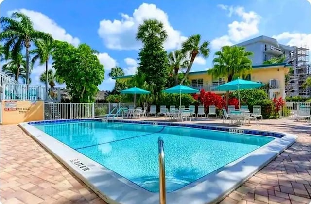 community pool featuring a patio area and fence