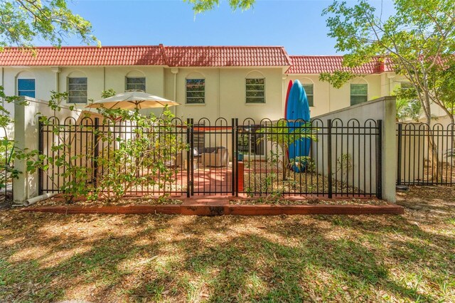 2700 Bayshore Blvd Unit 512, Dunedin, FL 34698 - rear view of house featuring a tiled roof, stucco siding, and a gate