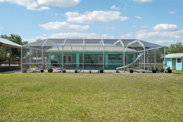 back of house featuring a lanai, an outdoor pool, and a yard
