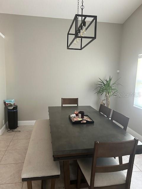 14305 Tennyson Dr, Hudson, FL 34667 - dining space with baseboards, a chandelier, and light tile patterned flooring