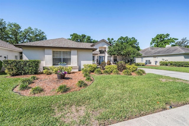 single story home with stucco siding, a front yard, and a shingled roof
