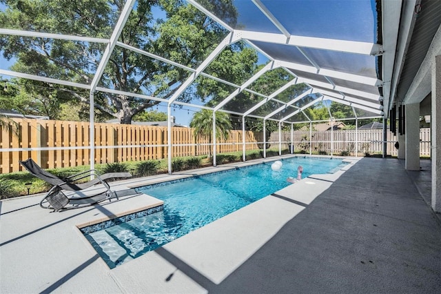 view of swimming pool featuring a fenced in pool, a patio, glass enclosure, and a fenced backyard