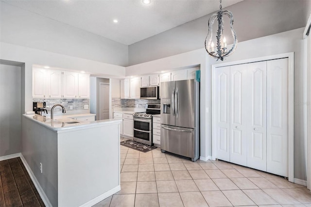 kitchen featuring tasteful backsplash, white cabinets, and stainless steel appliances