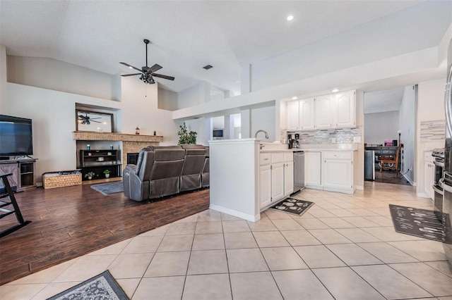 kitchen featuring a ceiling fan, white cabinetry, light countertops, light tile patterned floors, and lofted ceiling