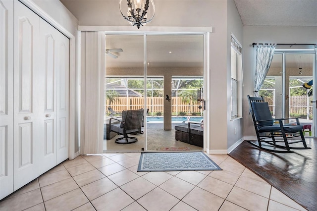 entrance foyer with light tile patterned floors, baseboards, and a chandelier