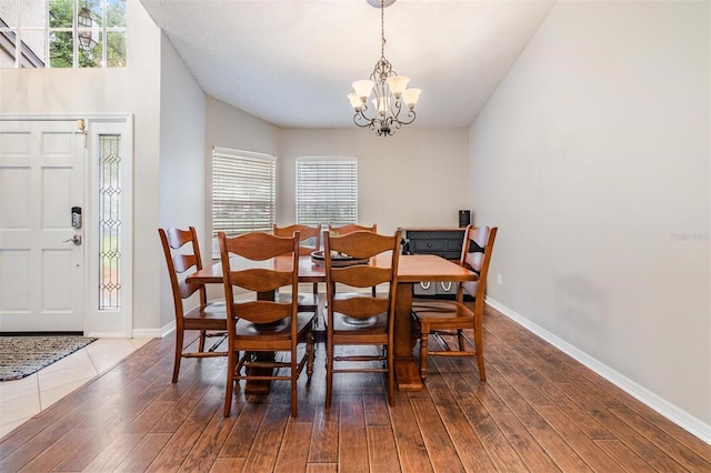 dining room with a notable chandelier, baseboards, and wood finished floors