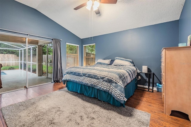 bedroom featuring access to exterior, a ceiling fan, lofted ceiling, and hardwood / wood-style floors