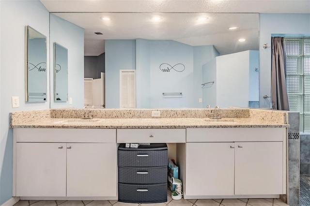bathroom featuring double vanity, walk in shower, recessed lighting, and a sink