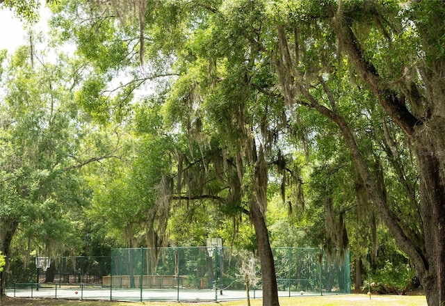 surrounding community featuring community basketball court, fence, and a tennis court