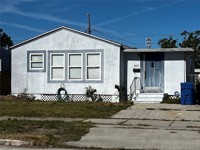 bungalow-style home with stucco siding