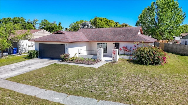 ranch-style house featuring a front yard, an attached garage, driveway, and stucco siding