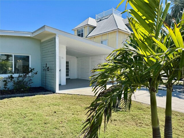 view of side of property with an attached carport and a yard