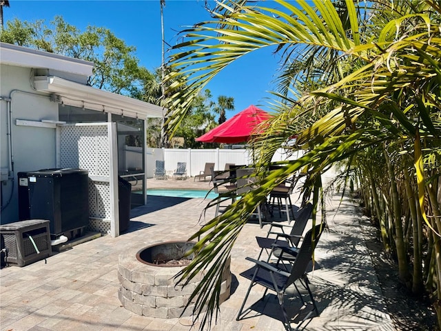 view of patio with central AC unit, a fenced backyard, a fenced in pool, and an outdoor fire pit