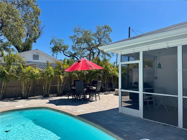 view of swimming pool with outdoor dining space, a fenced in pool, a patio, and fence