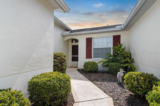 entrance to property featuring stucco siding