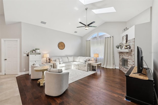 954 Cobblestone Ln, Tarpon Springs, FL 34688 - living room with visible vents, wood-type flooring, a brick fireplace, a ceiling fan, and a skylight