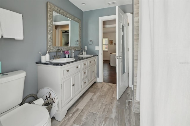 954 Cobblestone Ln, Tarpon Springs, FL 34688 - bathroom with visible vents, wood finished floors, toilet, and a sink