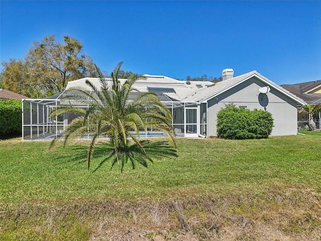 954 Cobblestone Ln, Tarpon Springs, FL 34688 - back of property with a lanai, a yard, and a chimney
