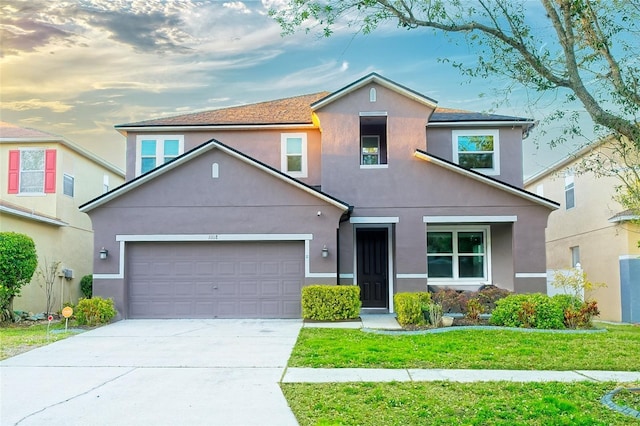 view of front facade featuring stucco siding, an attached garage, a front lawn, and concrete driveway