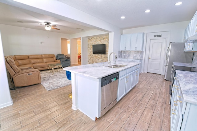 kitchen featuring wood tiled floor, a sink, stainless steel appliances, and open floor plan