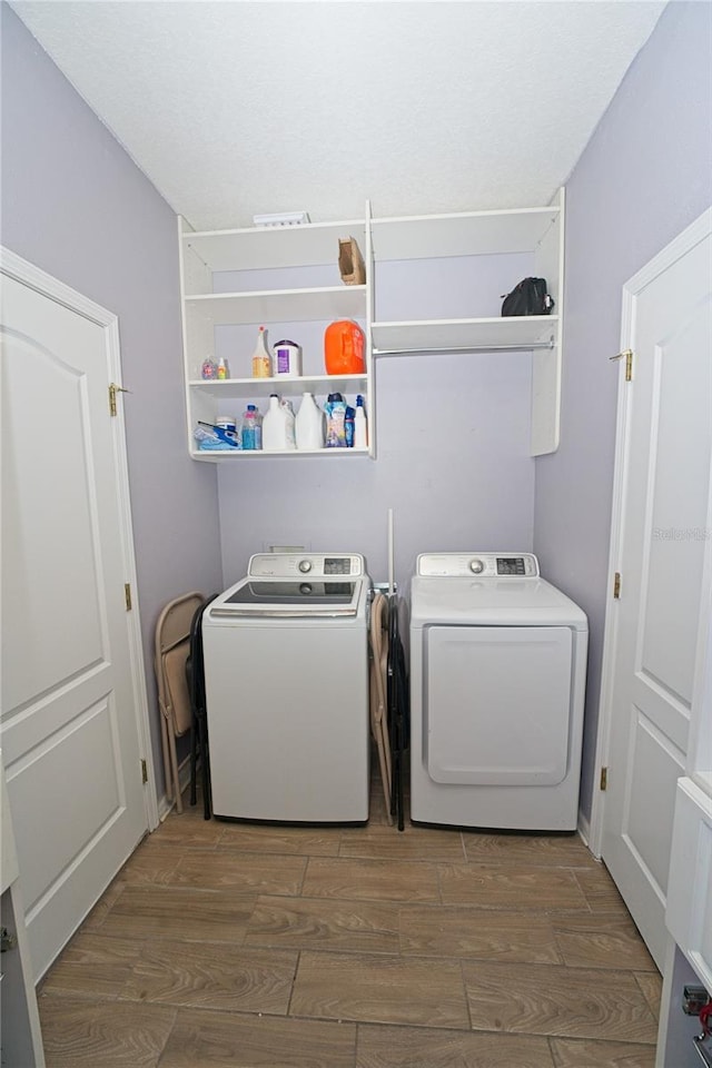 laundry area featuring washing machine and dryer, wood finished floors, and laundry area