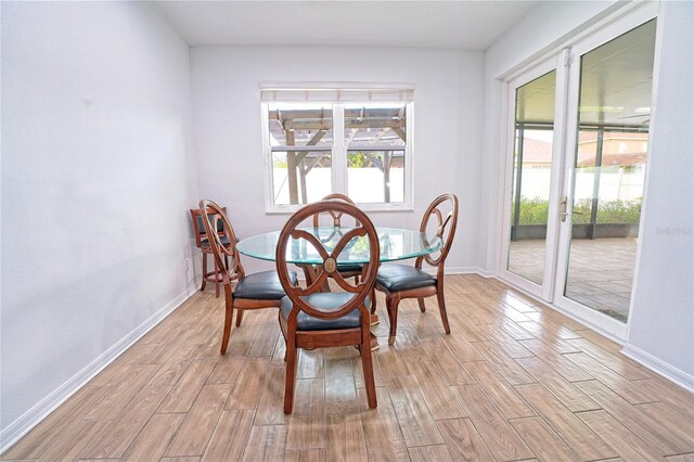 dining room featuring baseboards and light wood-style flooring