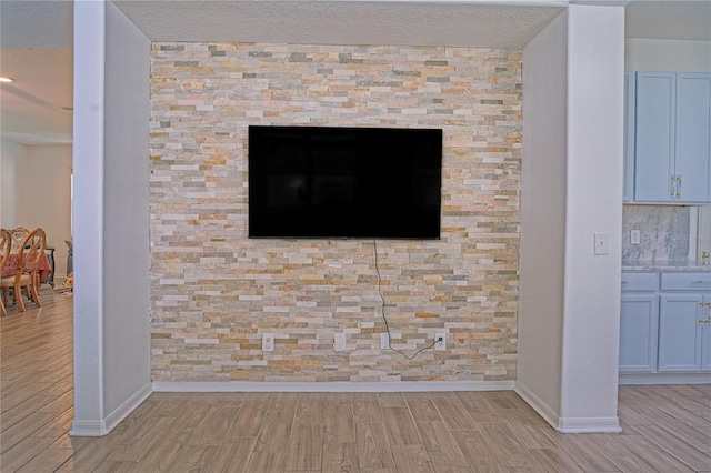 details with baseboards, a textured ceiling, and wood finish floors