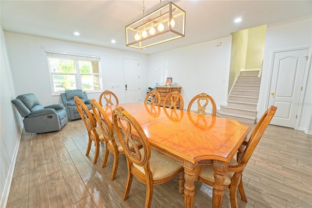 dining area featuring light wood-style flooring, baseboards, stairs, and recessed lighting