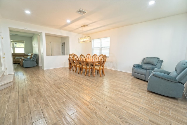 dining area with a wealth of natural light, visible vents, and light wood-style floors