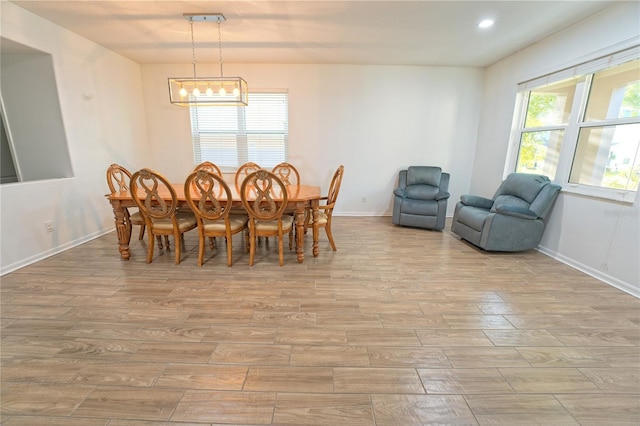 dining area with baseboards, a notable chandelier, wood finished floors, and recessed lighting