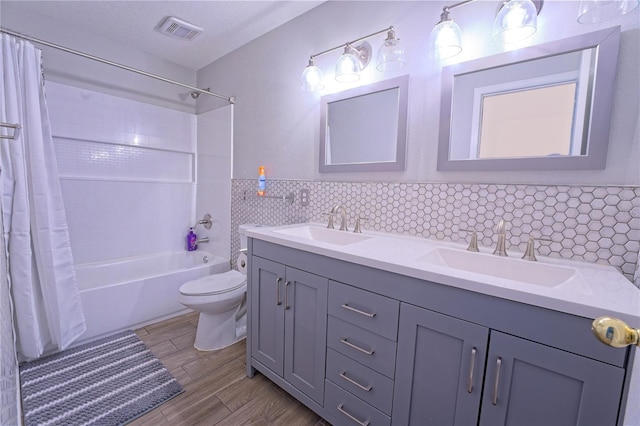 full bathroom featuring visible vents, a sink, toilet, and double vanity