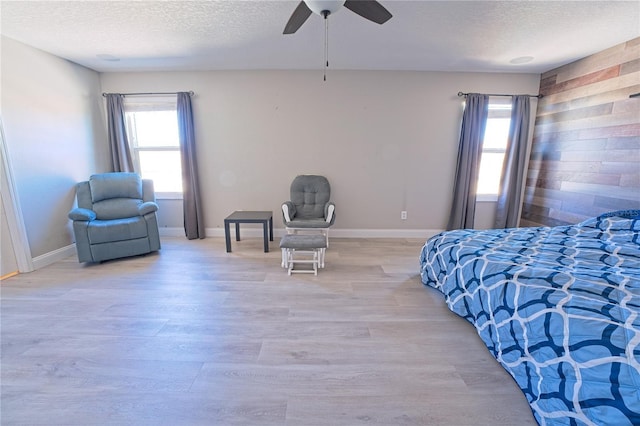bedroom featuring wood finished floors, multiple windows, and a textured ceiling